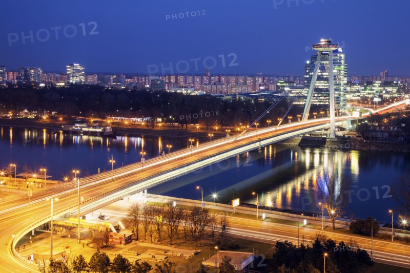 Illuminated bridge over river at night