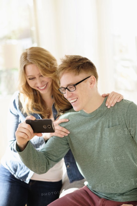 Young couple watching movie on smart phone.