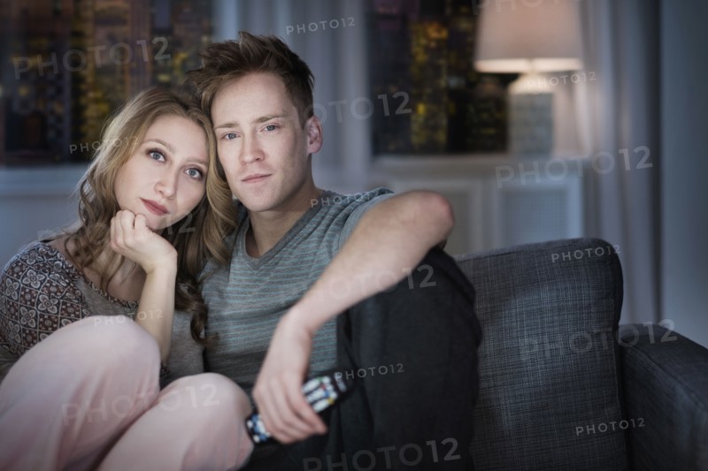 Young couple watching TV at night.