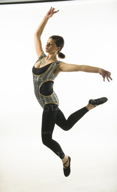 Young woman jumping on black background.