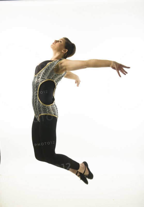 Young woman dancing against white background.