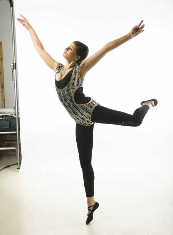 Young woman dancing against white background.
