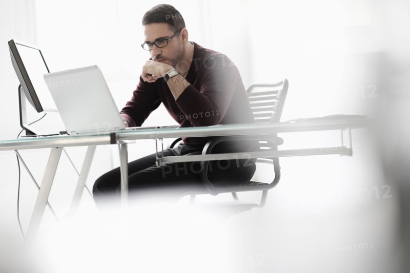 Man using laptop in office.