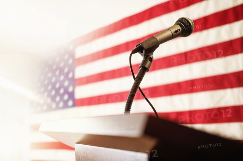 Lectern with American flag in background.