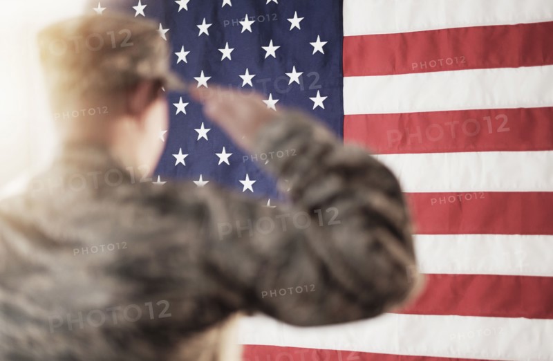 Soldier saluting American flag.