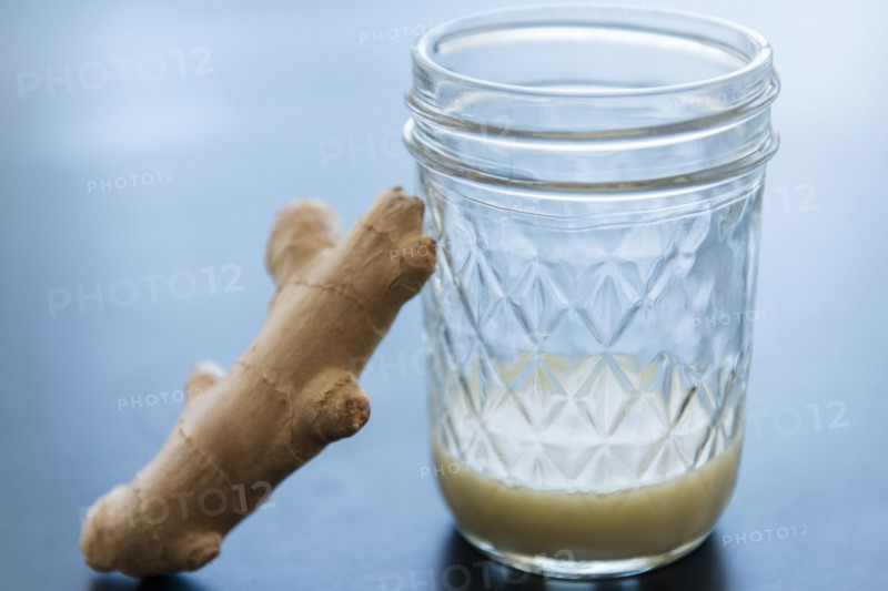 Ginger and homemade juice in drinking glass