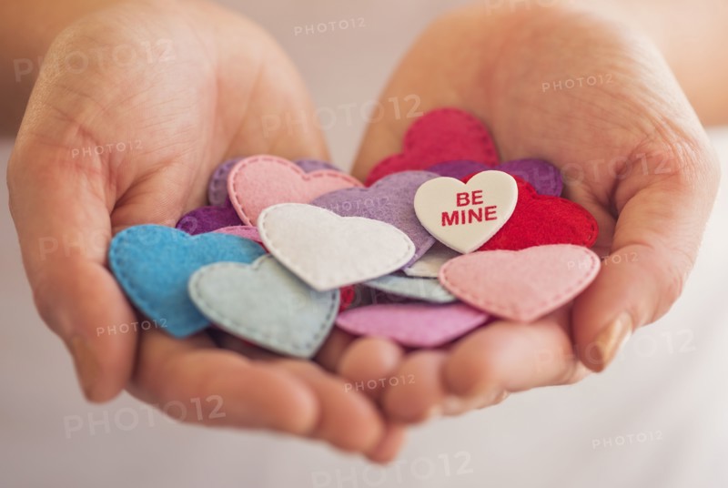 Close-up of woman's hands holding decorations in heart shape