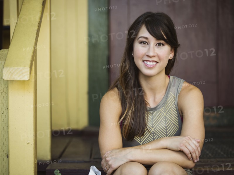 Portrait of young woman sitting on porch