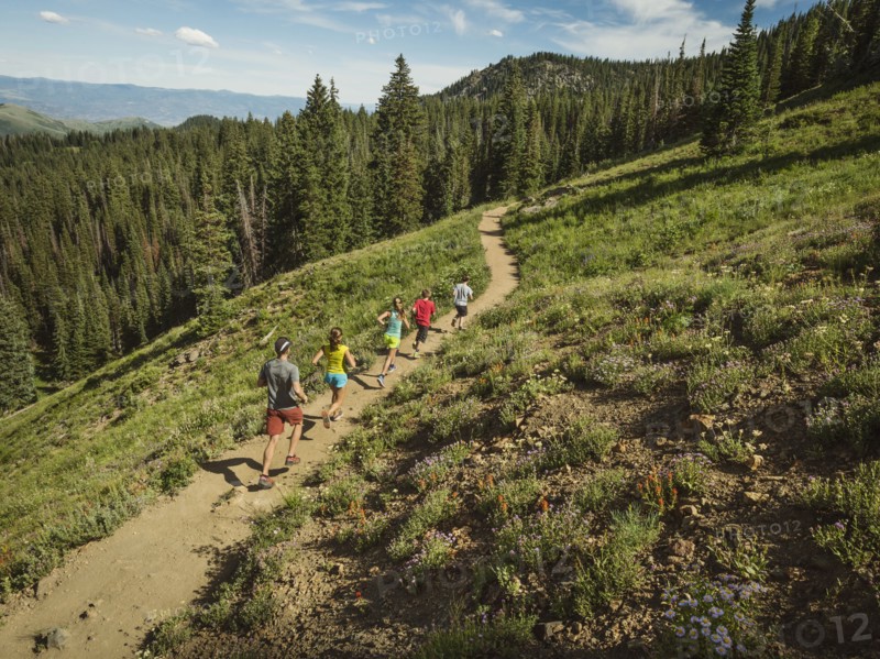 Family with three children (10-11, 12-13, 14-15) running in mountains