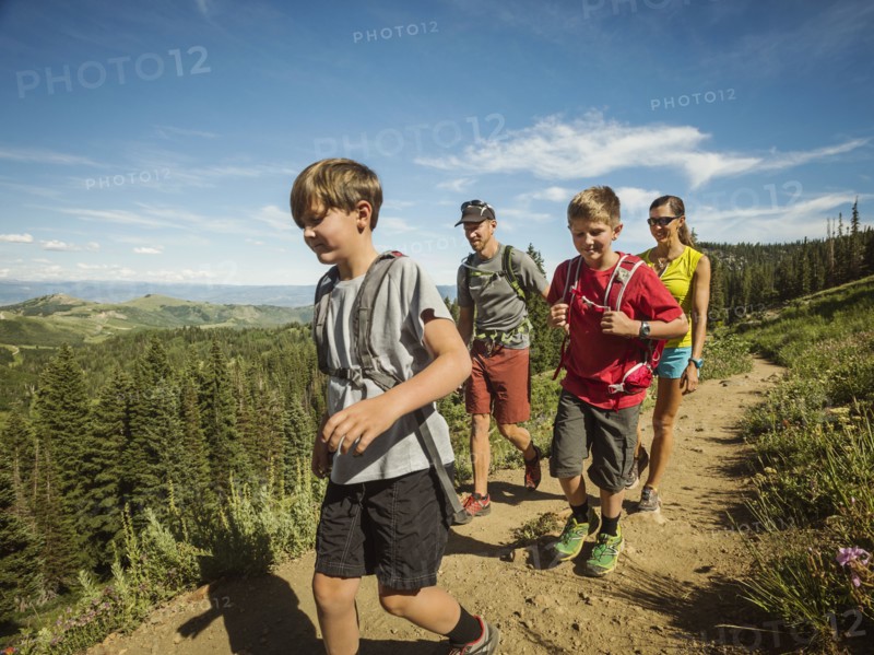 Family with two children (10-11, 12-13) hiking in mountains