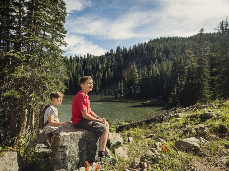 Two boys (10-11, 12-13) resting in forest