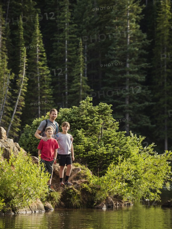 Father with sons (10-11, 12-13) by lake