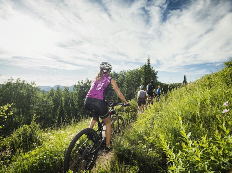 Family with children ( 10-11, 12-13) cycling in mountains
