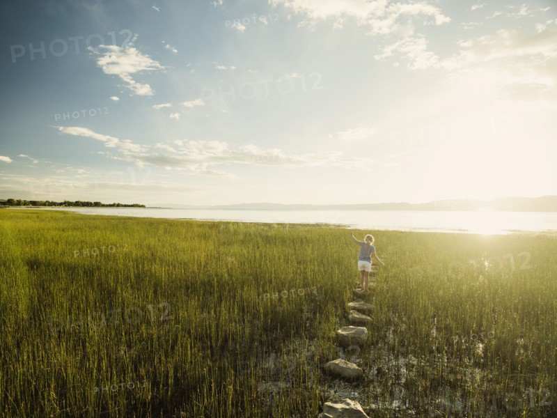 Small girl (4-5) walking on stepping stones in meadow