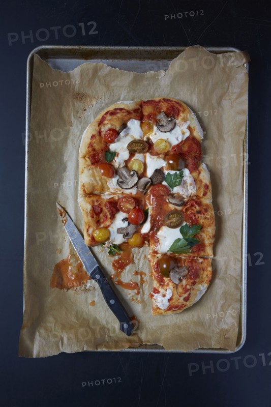 Homemade pizza on baking sheet