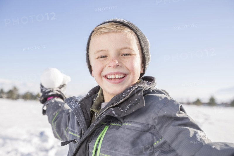 Portrait of boy (8-9) throwing snowball