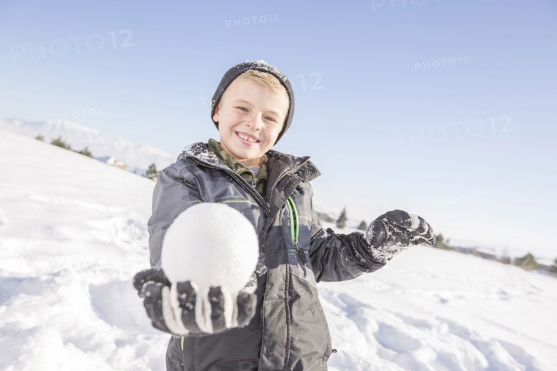 Portrait of boy (8-9) holding snowball