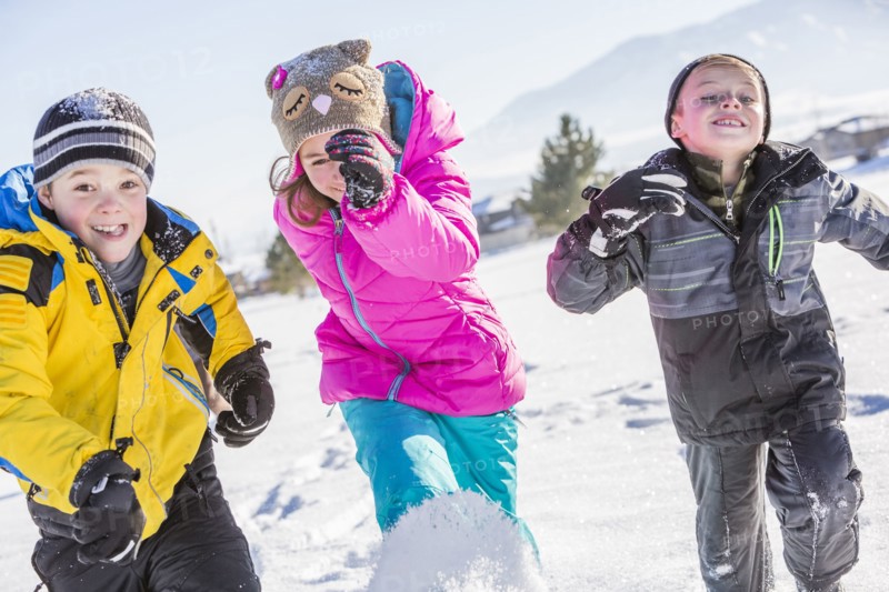 Children (8-9, 10-11) running in snow