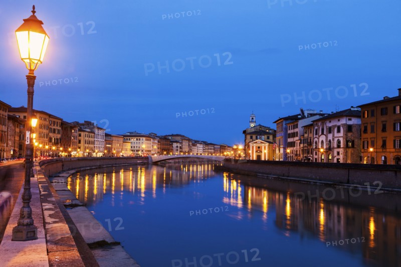 Illuminated townhouses by Arno river at night