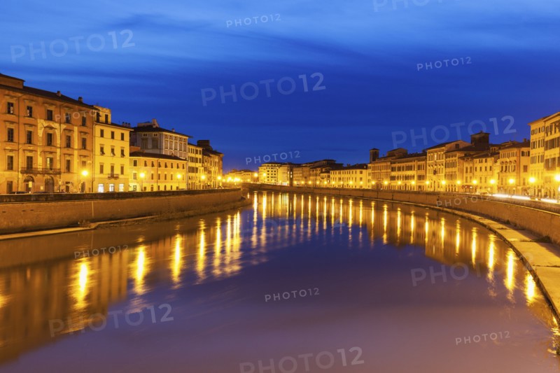 Illuminated townhouses by Arno river at night