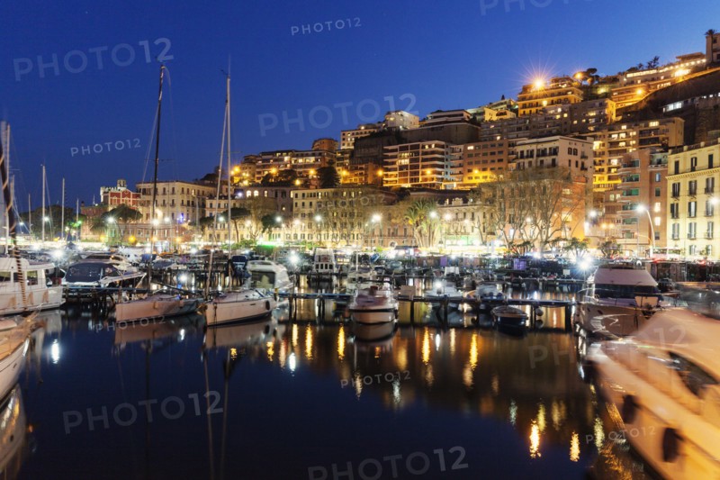 Boats in city marina at night