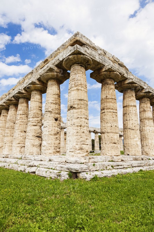 Old architectural columns of Paestum ruins on grass