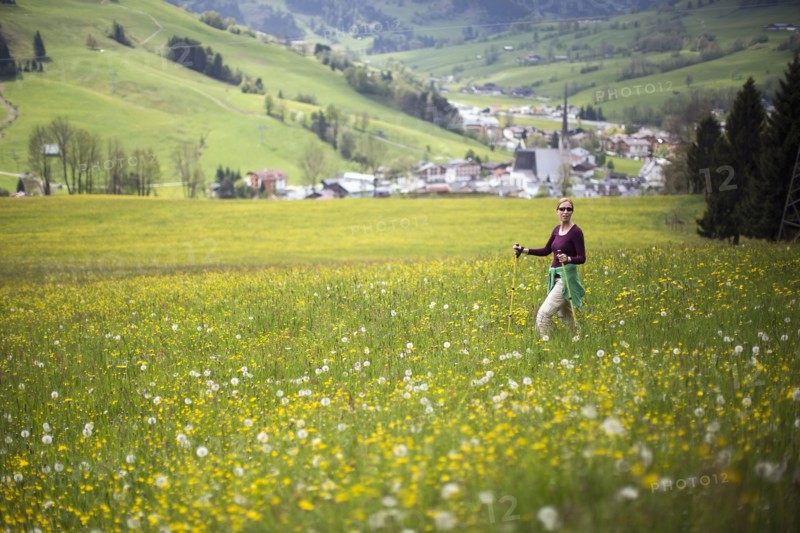 Woman walking with hiking poles in meadow