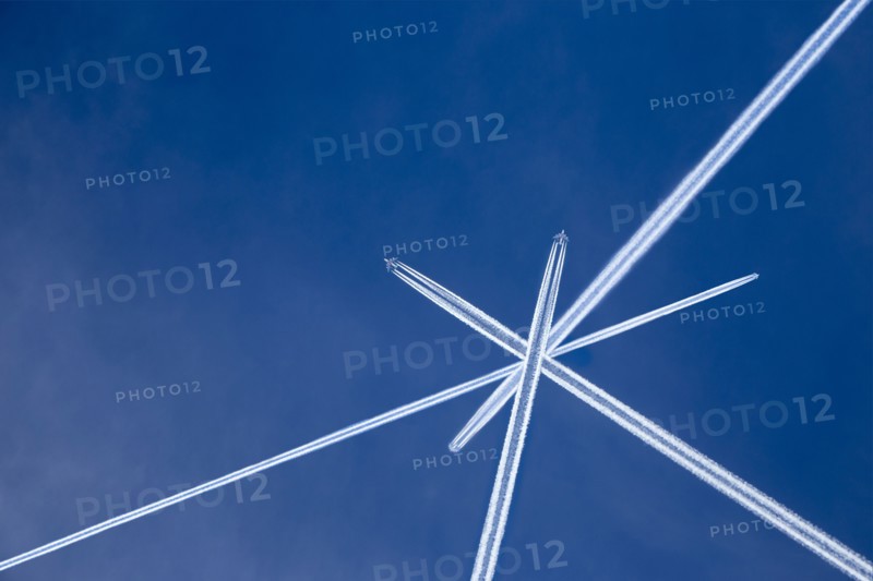 Crossed vapor trails of airplanes in blue sky