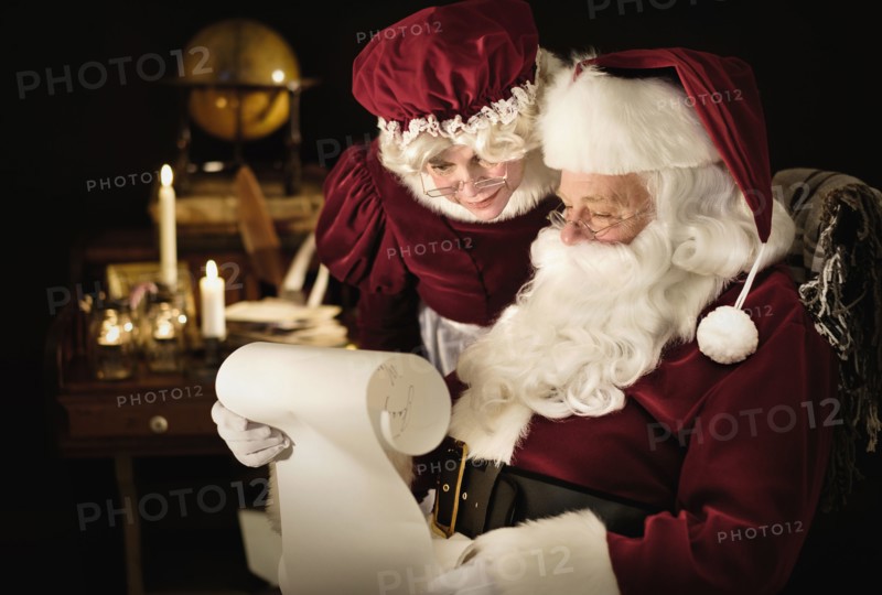 Santa and Mrs. Claus reading child's letter.