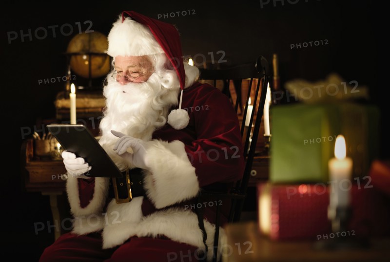 Santa Claus using digital tablet.