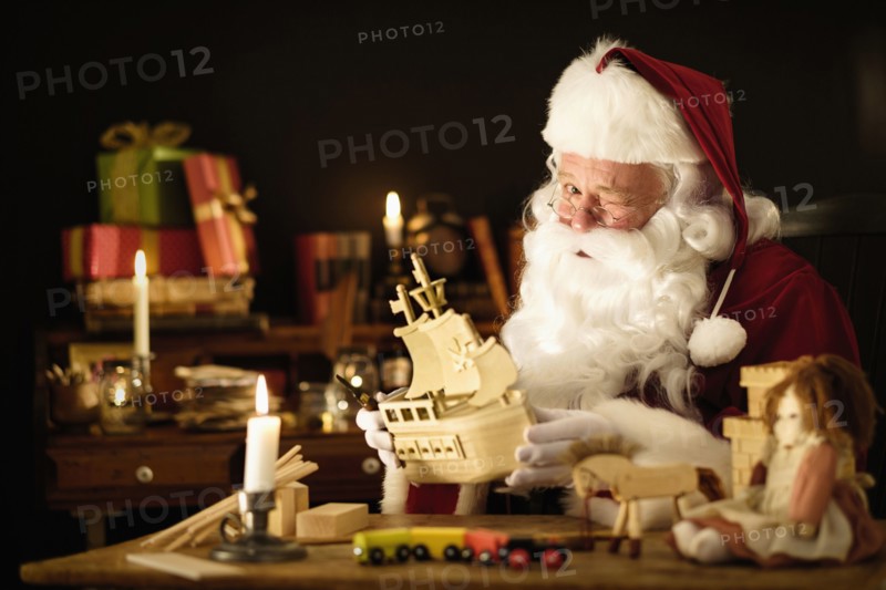 Santa Claus making wooden toy and winking.