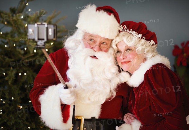 Santa and Mrs. Santa taking selfie with monopod.