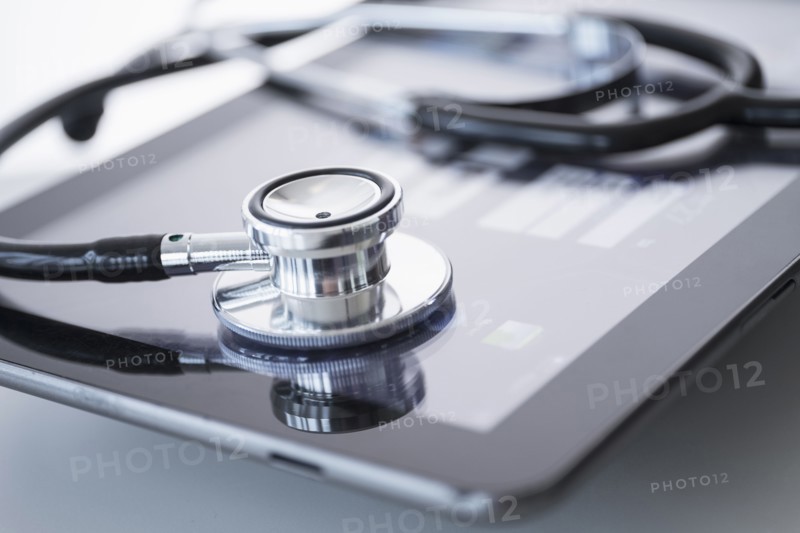 Stethoscope lying on digital tablet.