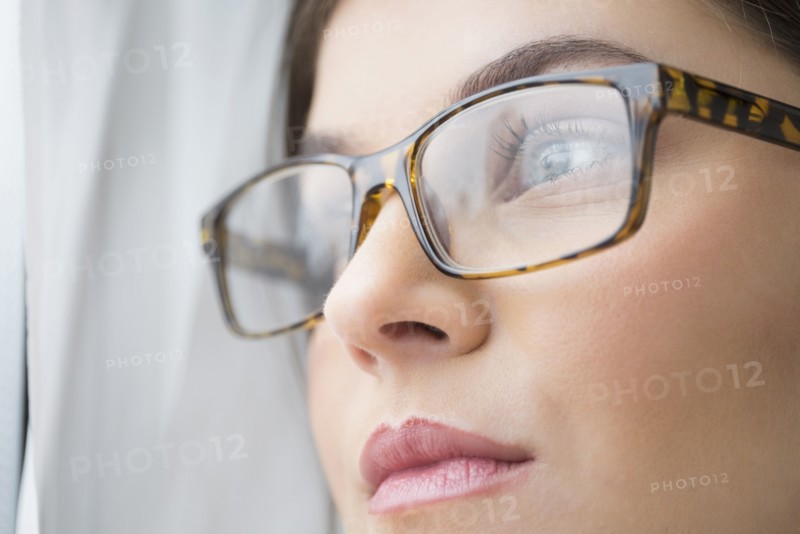Close up of young woman with blue eyes wearing glasses.