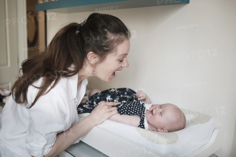Mother playing with baby daughter (2-5 months).