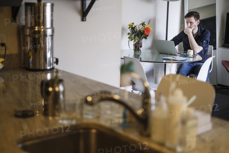 Man working on laptop at home.