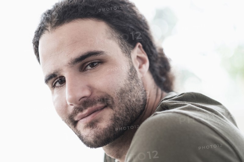 Portrait of young man with long curly hair.