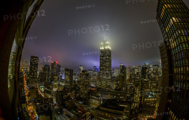 Empire State Building shrouded in night fog. USA, New York, New York City.