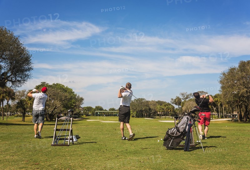 Three men playing golf