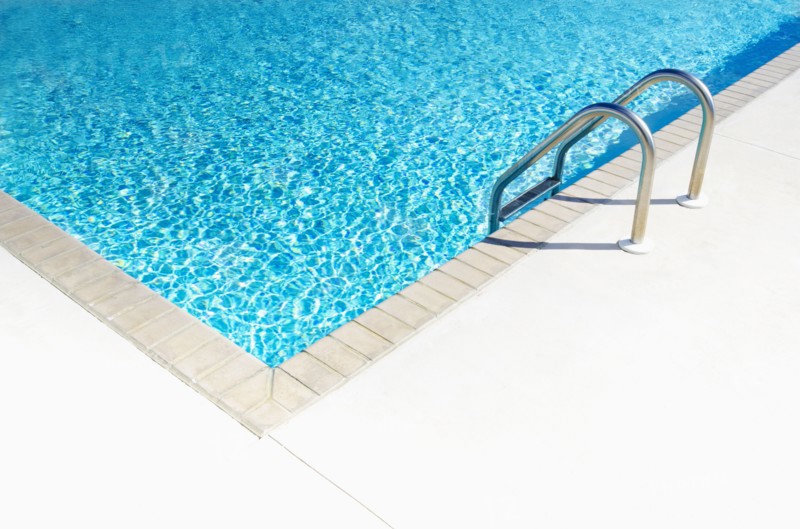 Edge of empty swimming pool in sunlight