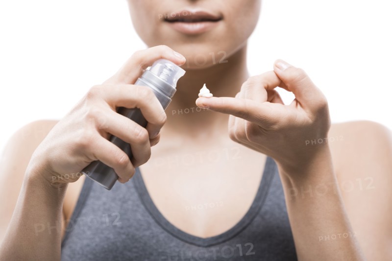 Young woman applying moisturizer