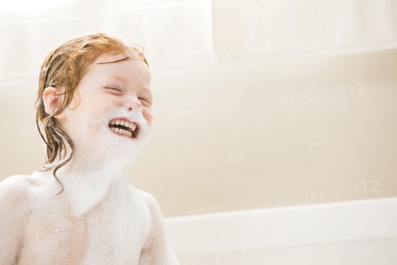 Smiling girl (4-5) having bubble bath