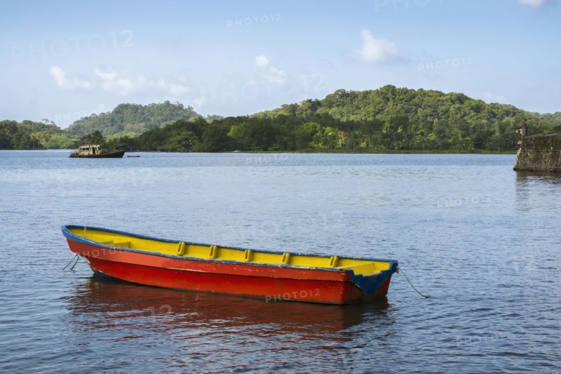 Boat on bay with green hills in background