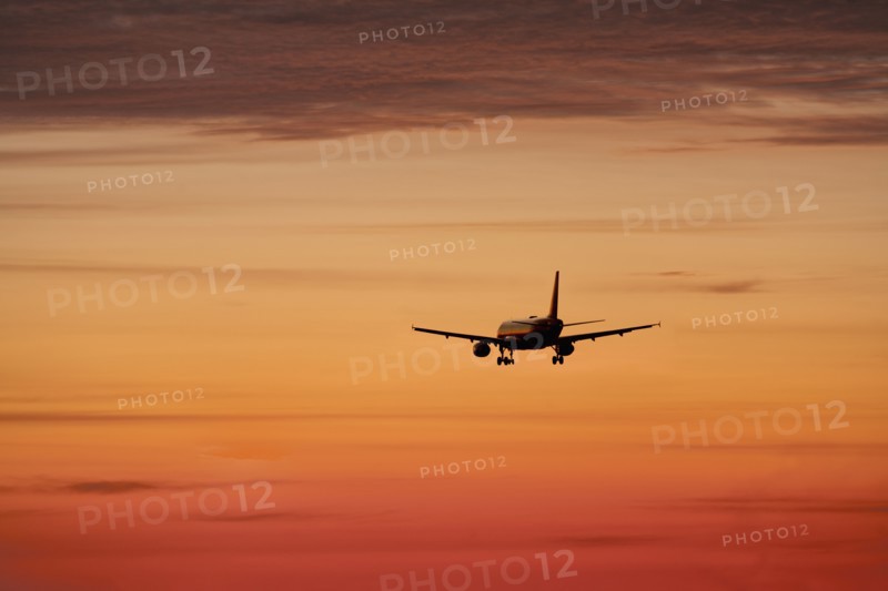 Airplane against orange sky