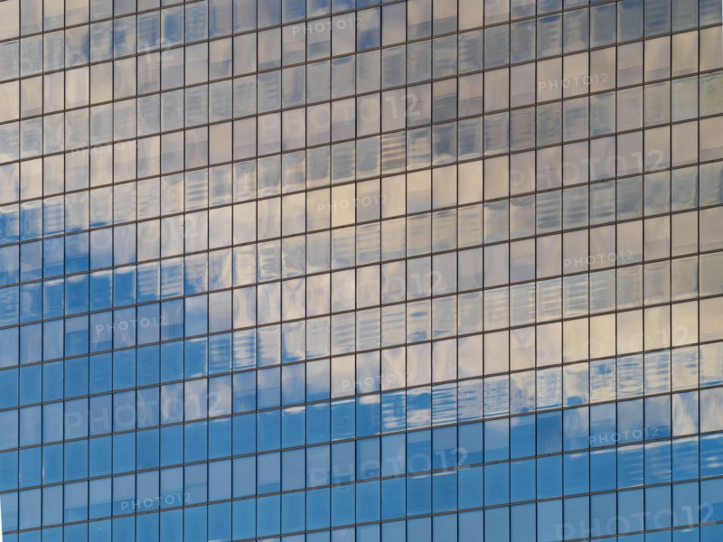 Sunlight and clouds reflecting in windows of office building