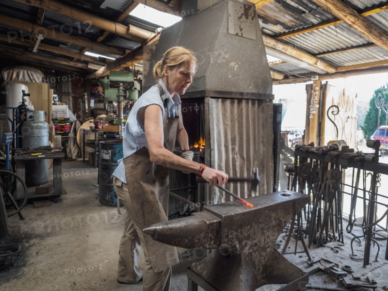 Female blacksmith working in workshop