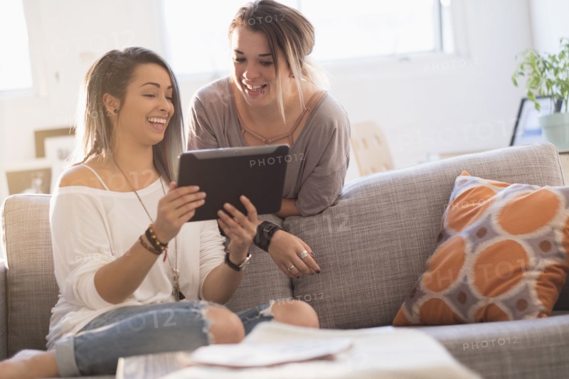 Young women using digital table at home.