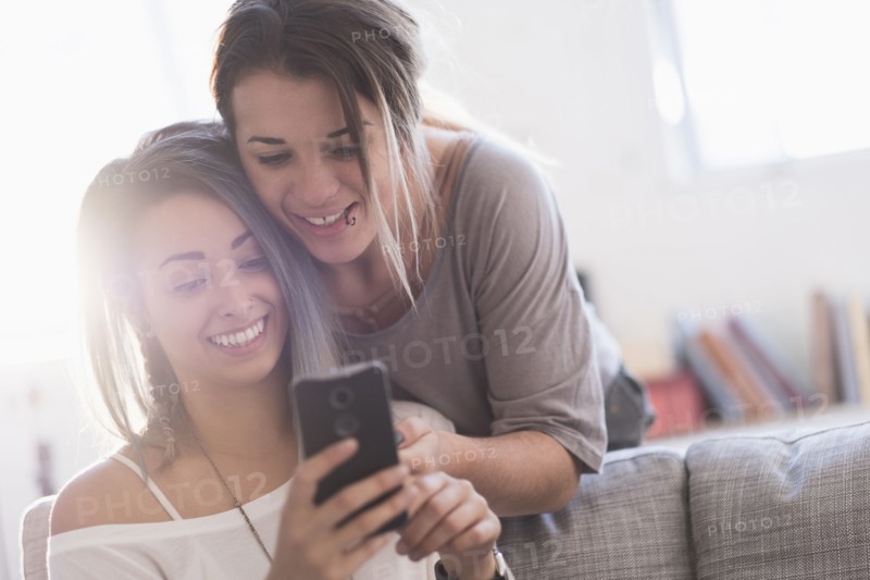 Young women using mobile phone at home.