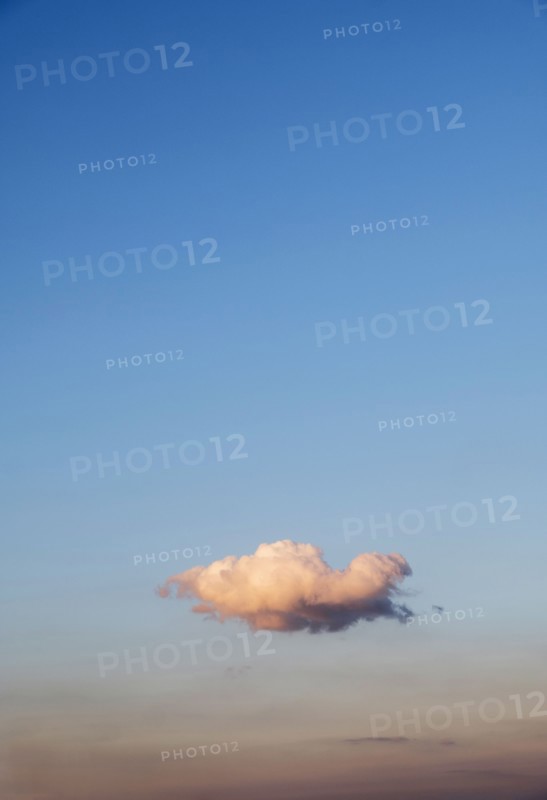 Single cloud on blue sky at sunset.