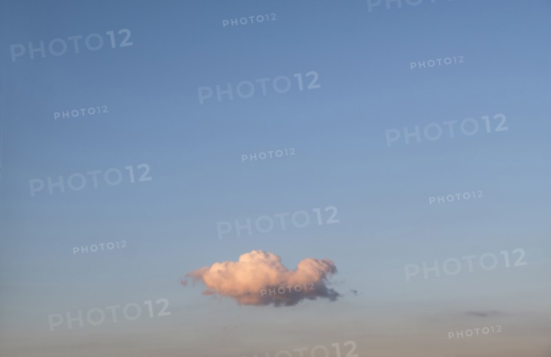 Single cloud on blue sky at sunset.